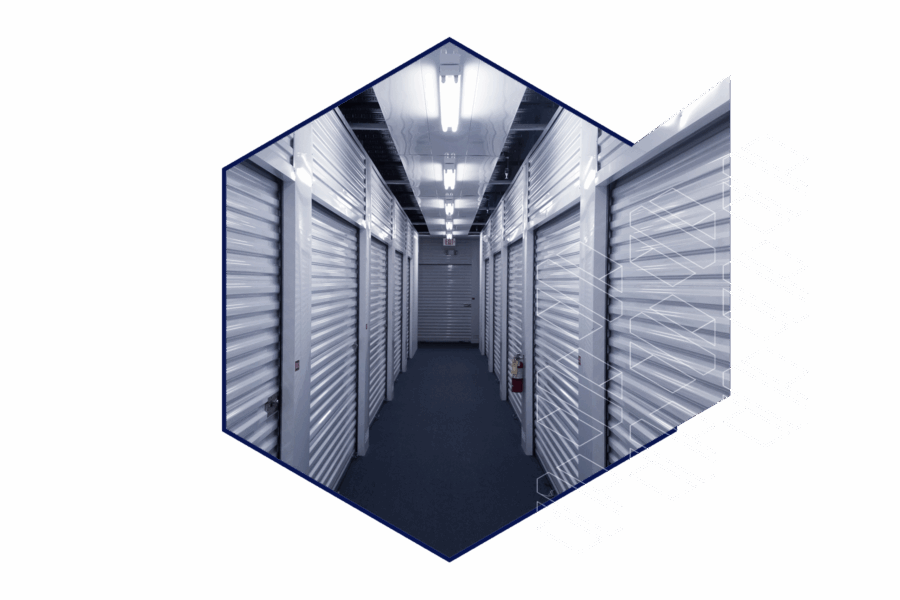 A hallway lined with closed metal storage unit doors under fluorescent lighting, shown within a hexagonal frame.