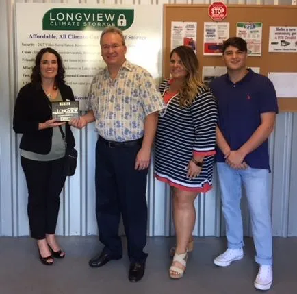Bill Gibbs and family receiving a certificate at the longview chamber of commerce ribbon cutting